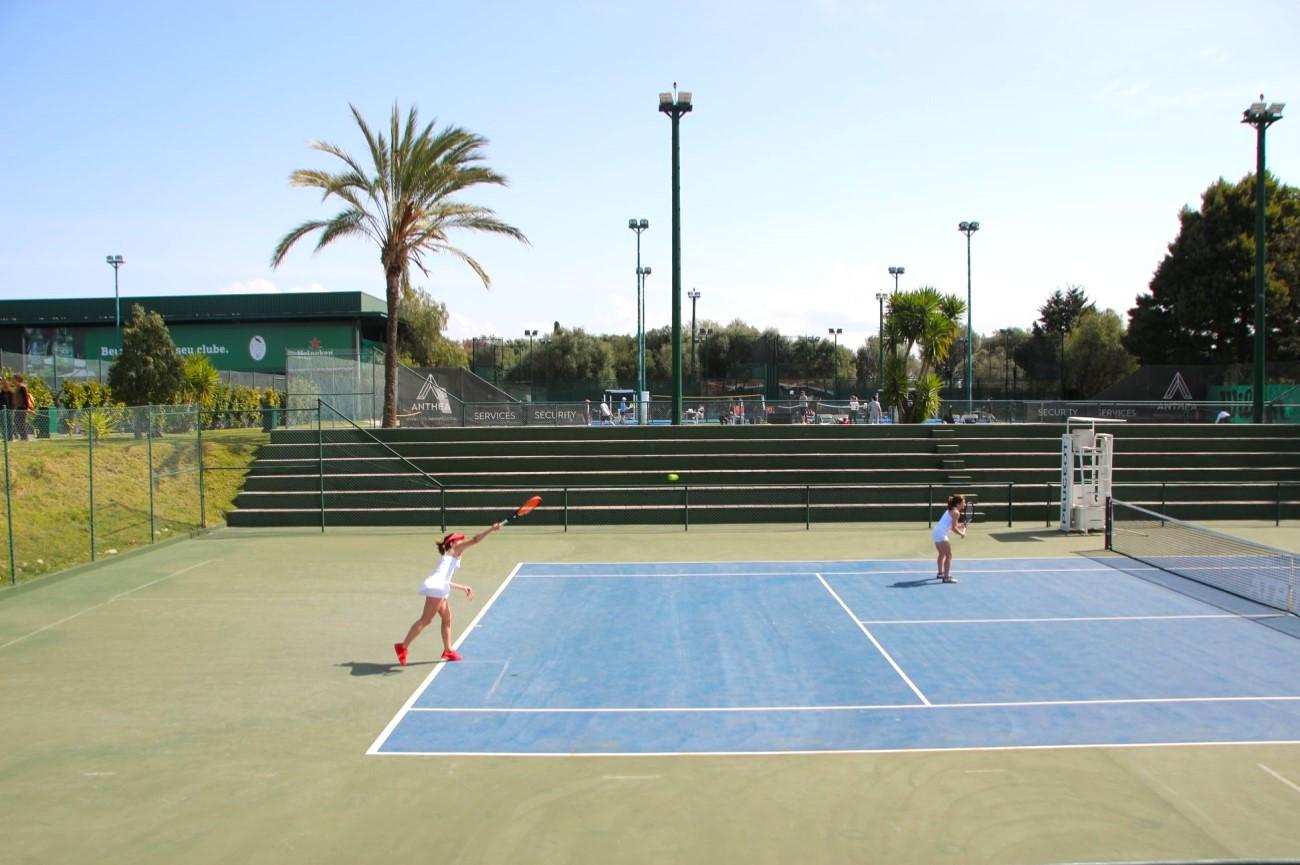 Giocatori su un campo da tennis all'aperto in superficie dura al Lisboa Racket Centre durante il giorno