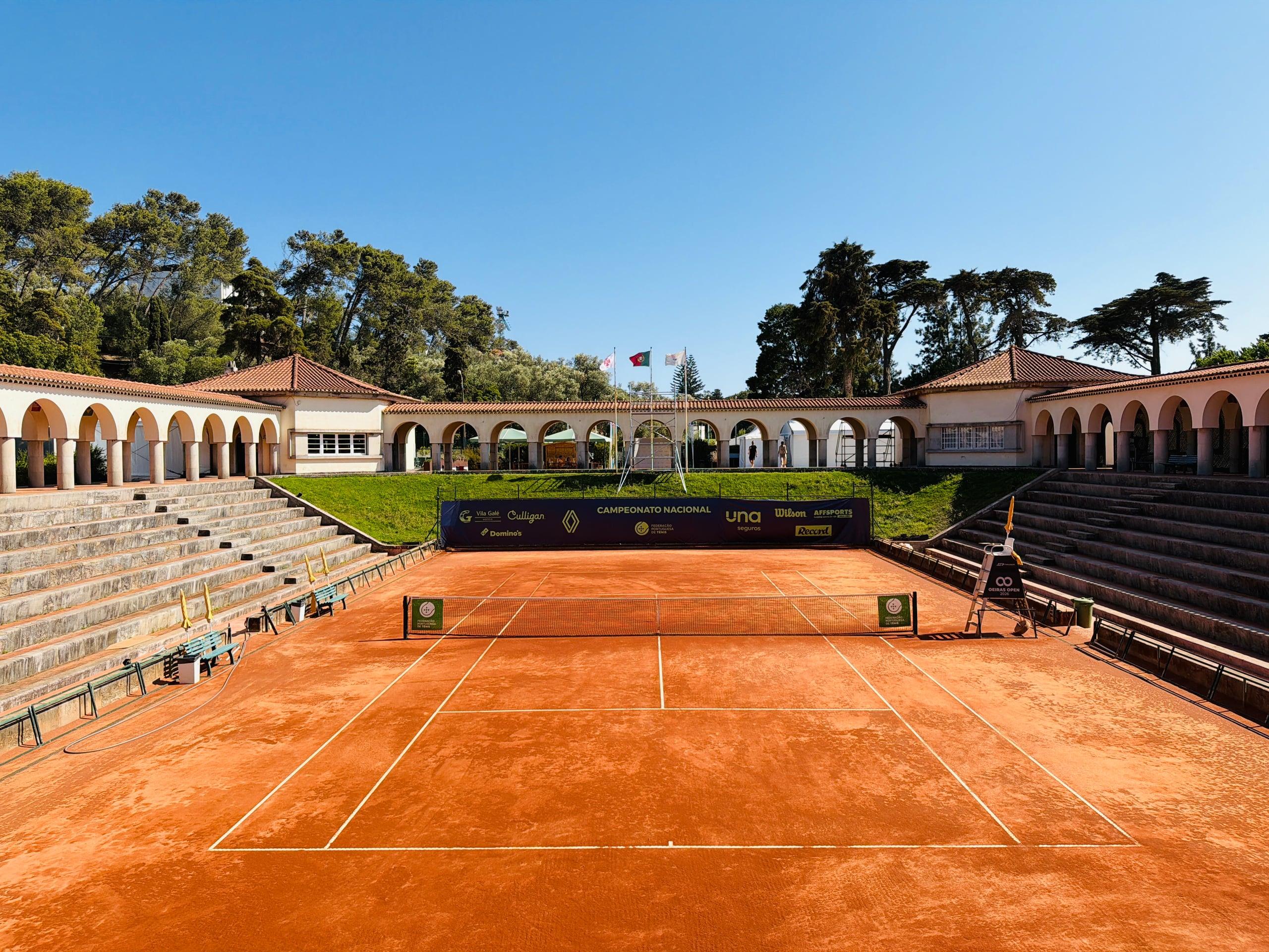 Campo centrale in terra rossa e tribune del Complexo de Ténis do Jamor in una giornata di sole