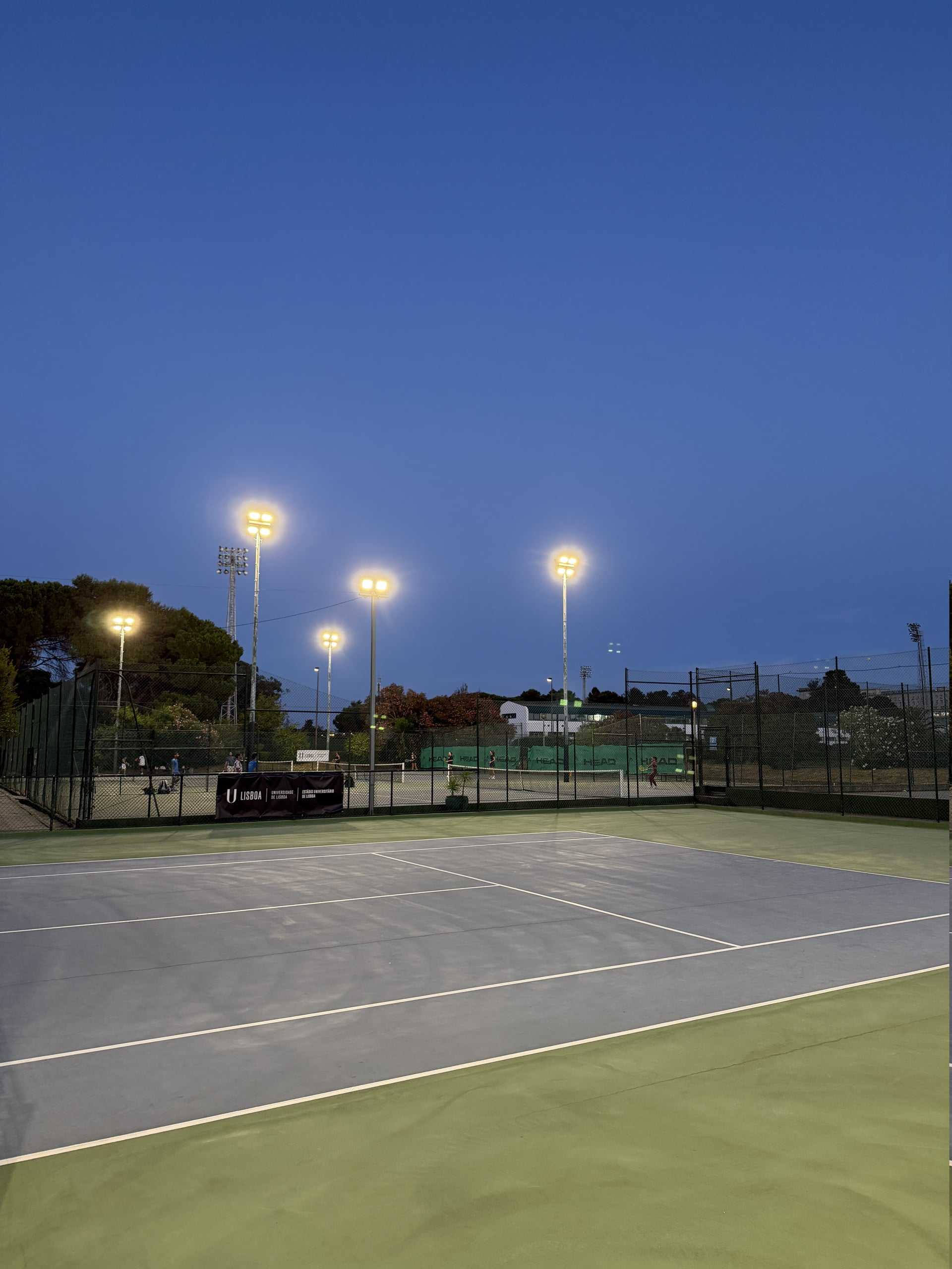 Courts de tennis extérieurs en dur éclairés au Rackets Pro EUL au crépuscule