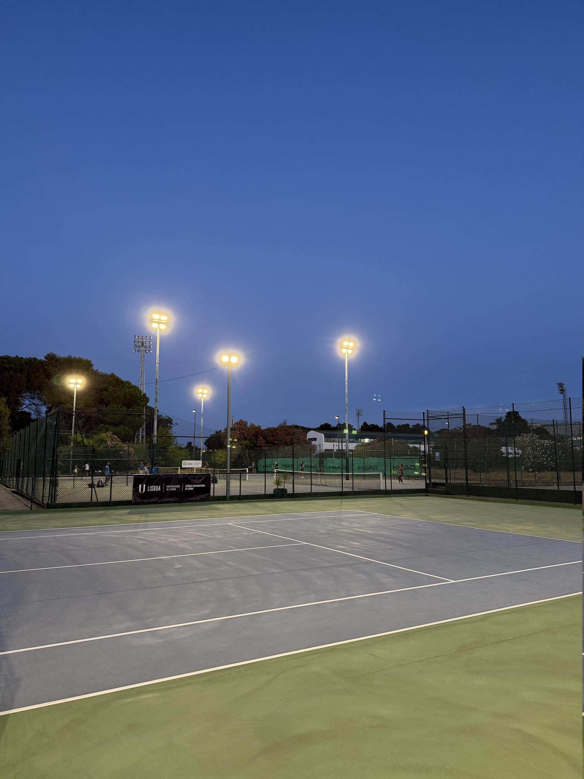 Quadras de tênis externas de piso duro iluminadas no Rackets Pro EUL ao anoitecer
